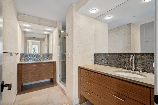 a bathroom with a granite countertop sink a toilet and shower