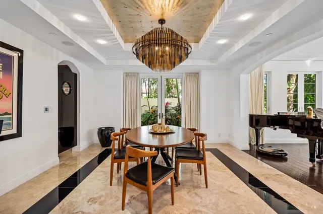 a dining room with furniture a chandelier and wooden floor