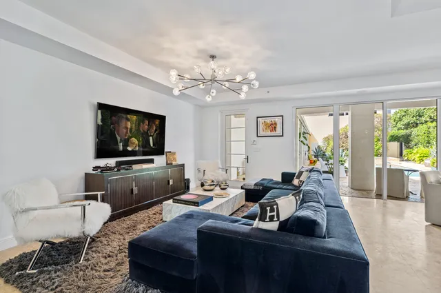 a living room with furniture a flat screen tv and a large window