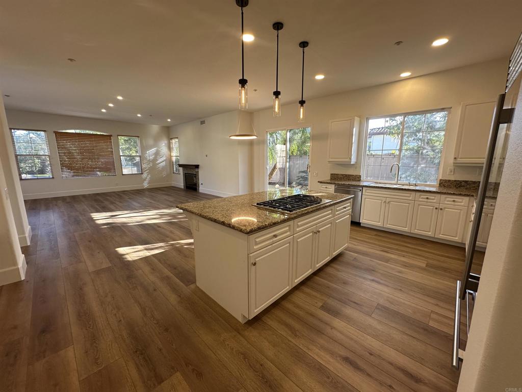 a kitchen with stainless steel appliances granite countertop a stove a sink and a refrigerator