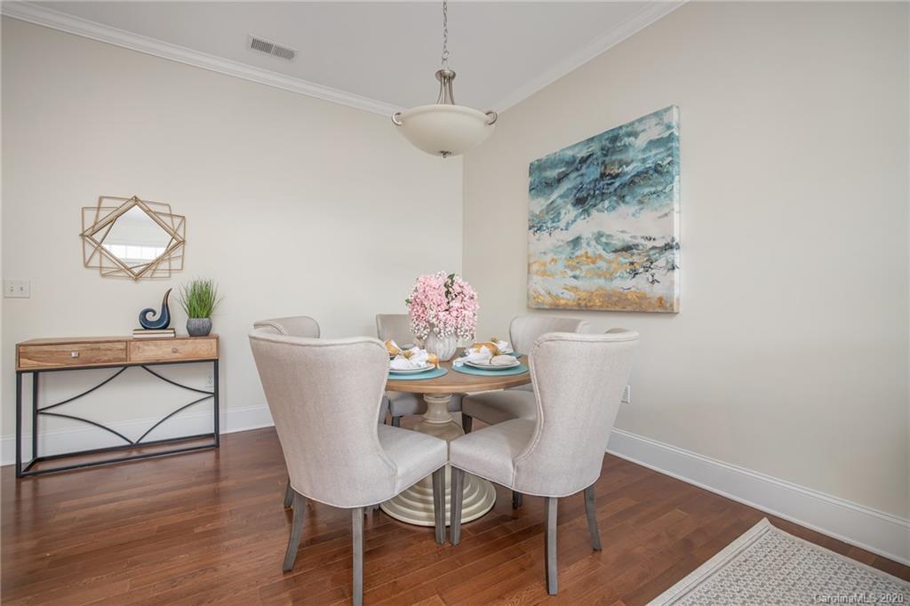 5425 Closeburn Road, Unit 212 Charlotte, NC 28210 - Photo 6 of 14 a dining room with furniture wooden floor and a chandelier