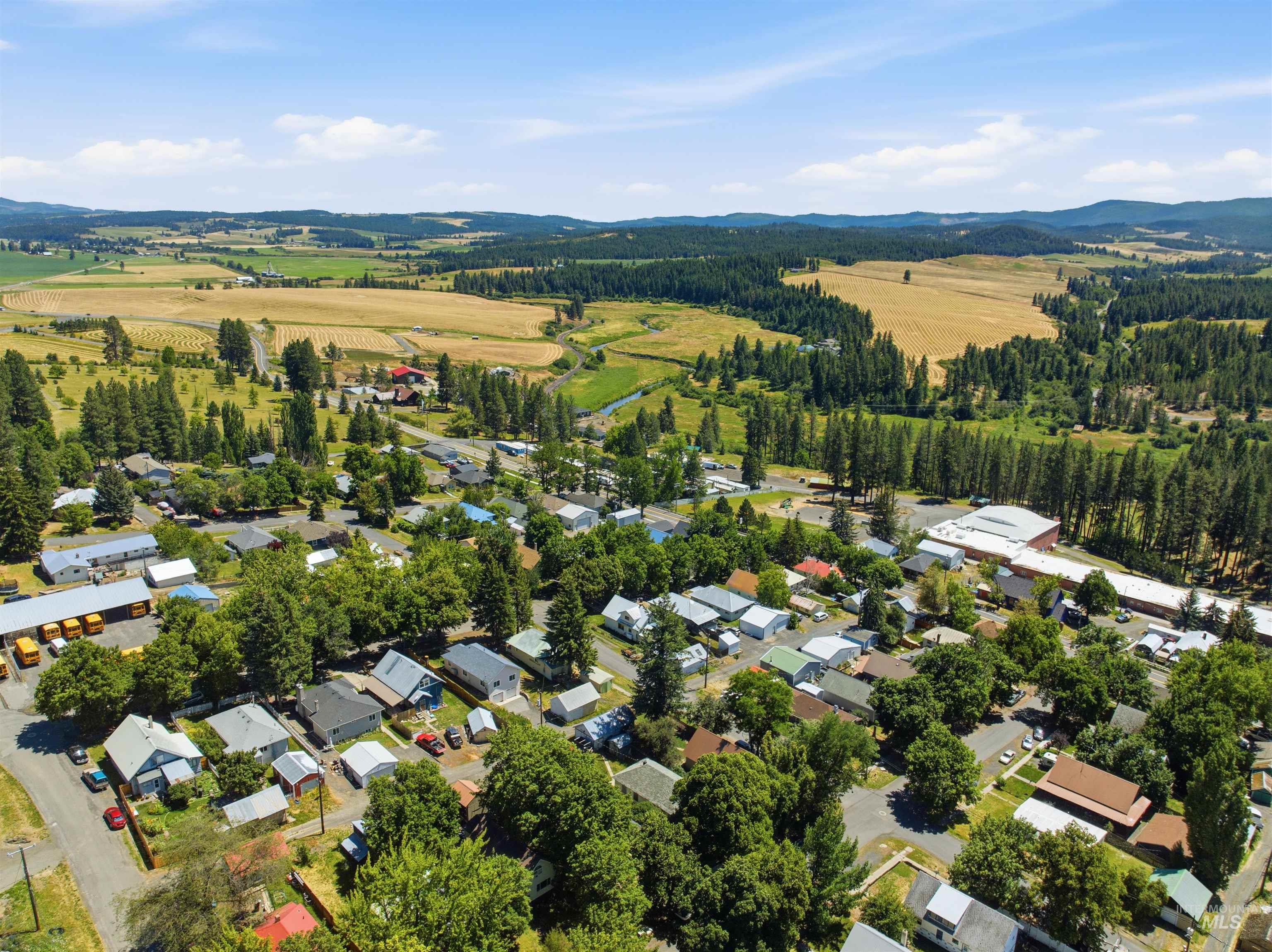 735 Oak Street Potlatch, ID 83855 - Photo 28 of 30 Aerial perspective showcasing a residential community surrounded by expansive agricultural fields and forested hills