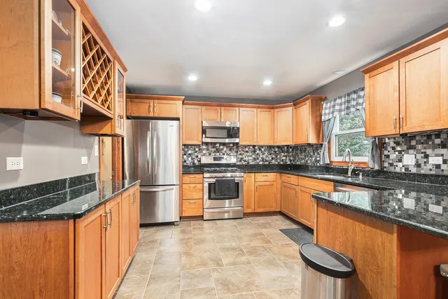 a large kitchen with stainless steel appliances granite countertop a stove a sink and dishwasher