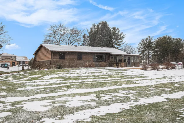 a front view of a house with a yard covered with trees