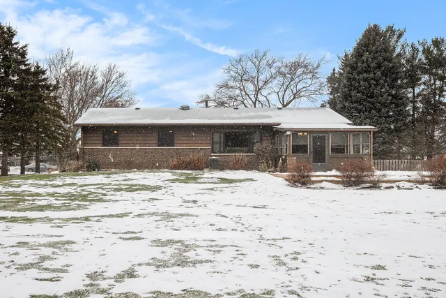 a front view of a house with a yard covered in snow