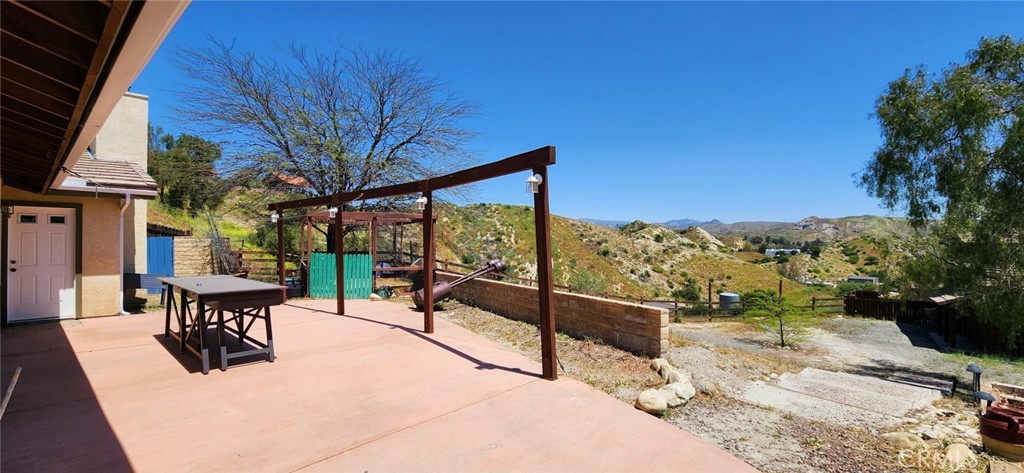 29932 Louis Avenue Canyon Country, CA 91351 - Photo 29 of 46 a view of a patio with a table chairs and wooden fence