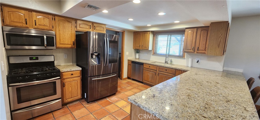 29932 Louis Avenue Canyon Country, CA 91351 - Photo 6 of 46 a kitchen with stainless steel appliances granite countertop a refrigerator stove and sink