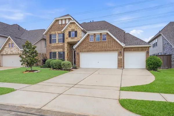 a front view of a house with a yard and garage