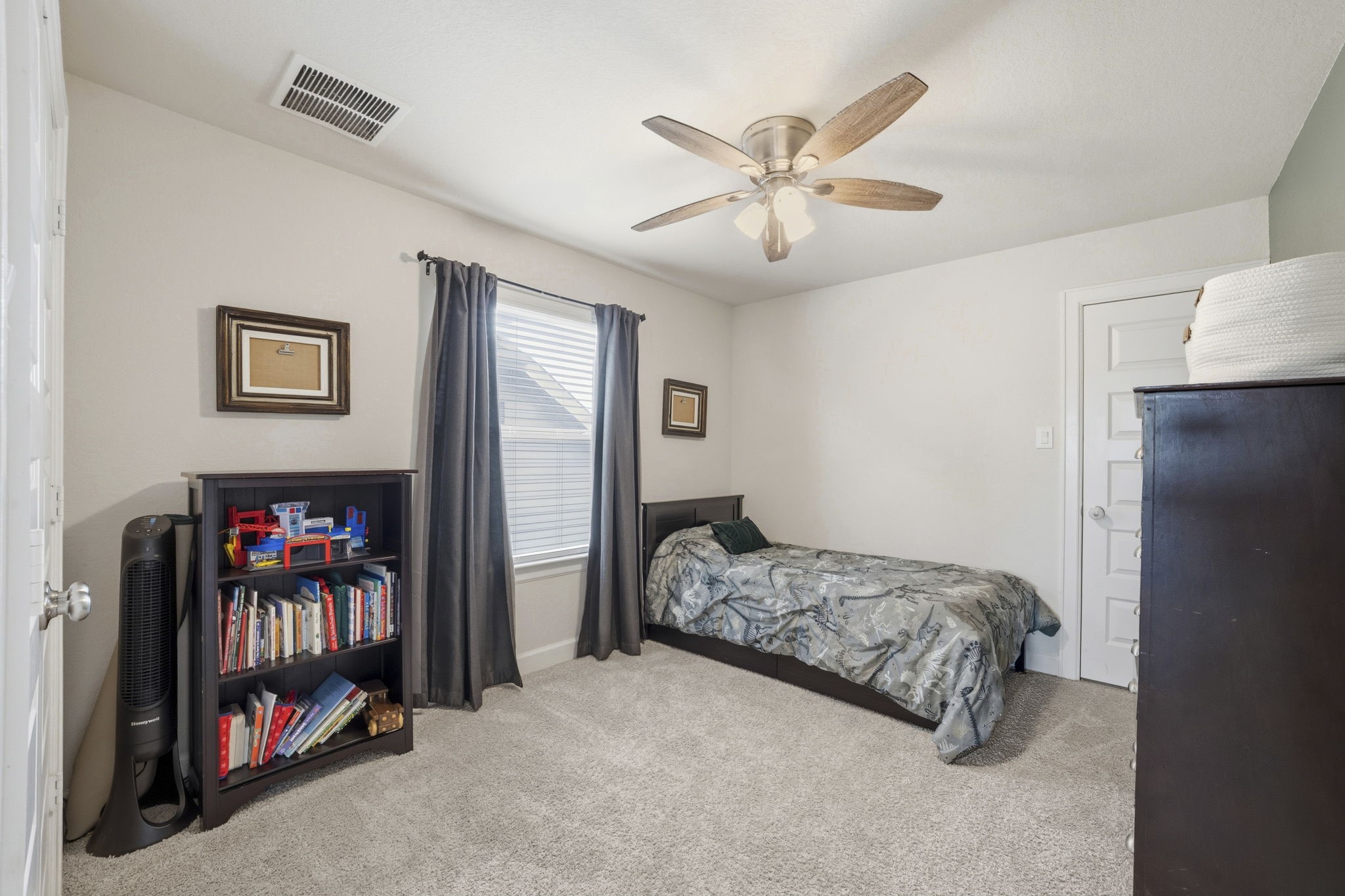 7618 Trailing Oaks Drive Spring, TX 77379 - Photo 27 of 33 a bedroom with a bed and a chandelier