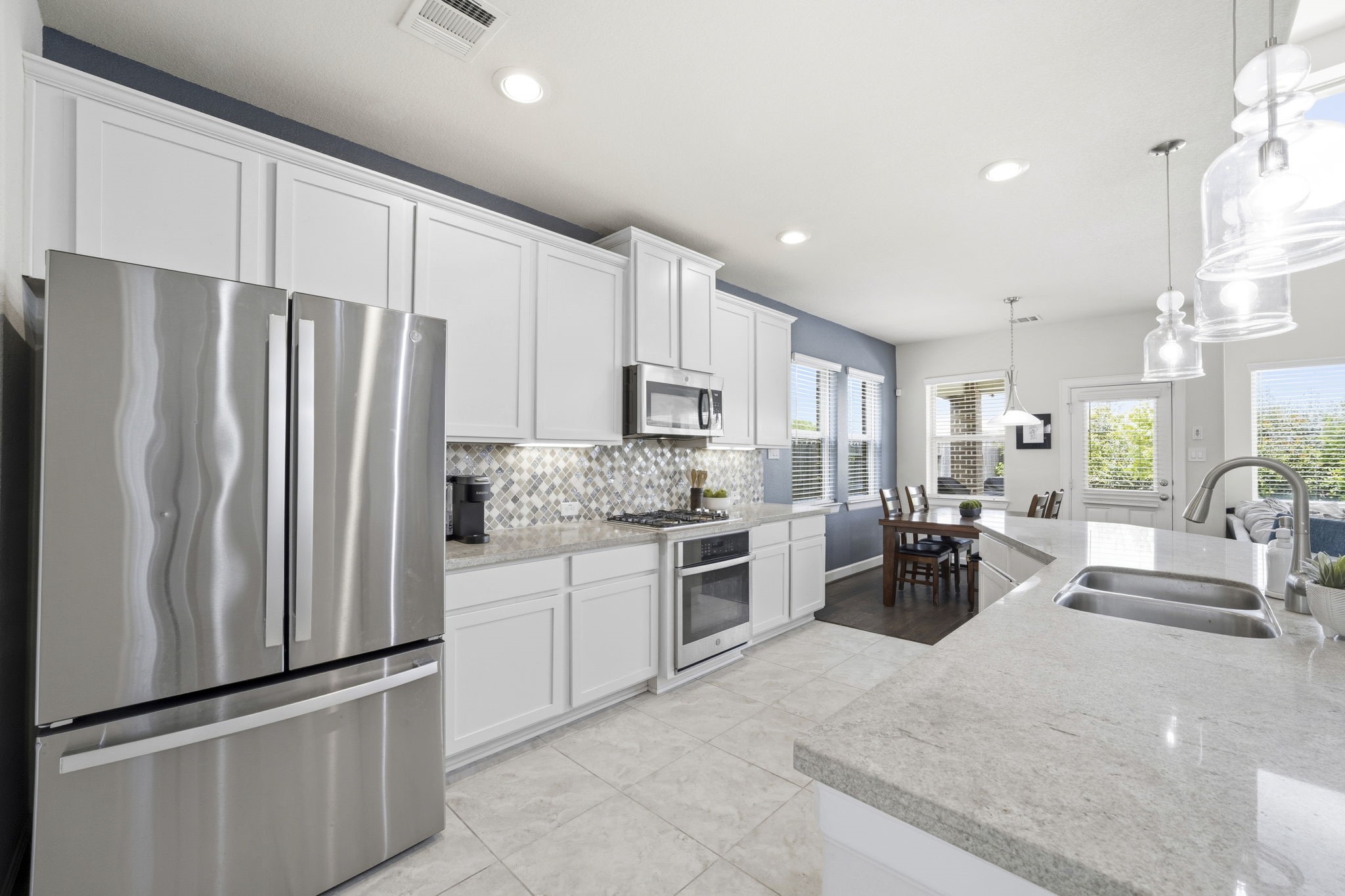 7618 Trailing Oaks Drive Spring, TX 77379 - Photo 9 of 33 a kitchen with stainless steel appliances granite countertop a refrigerator oven stove a sink and a refrigerator