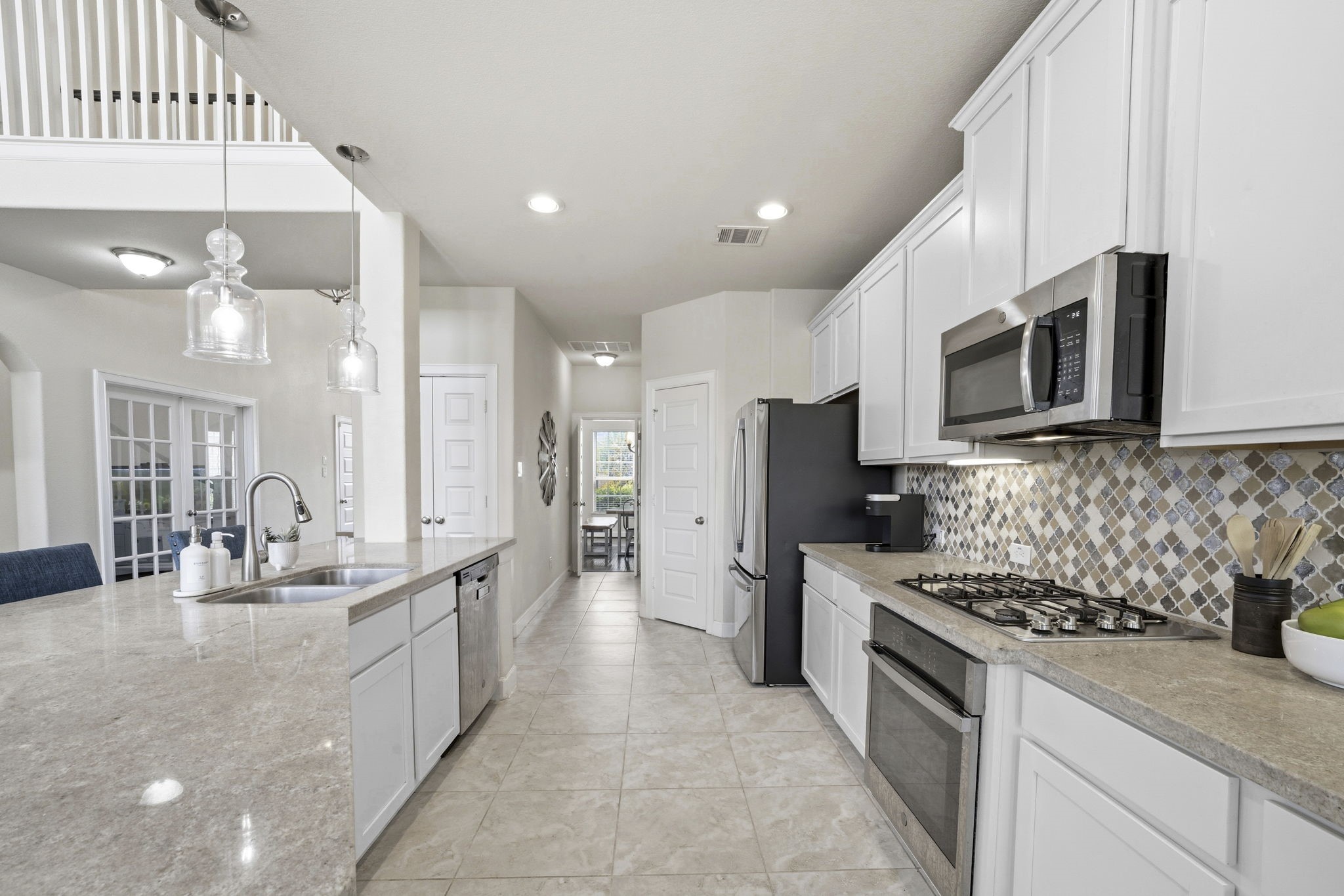 7618 Trailing Oaks Drive Spring, TX 77379 - Photo 10 of 33 a kitchen with stainless steel appliances kitchen island granite countertop a sink and a stove