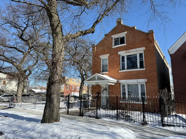 a front view of a house with a tree