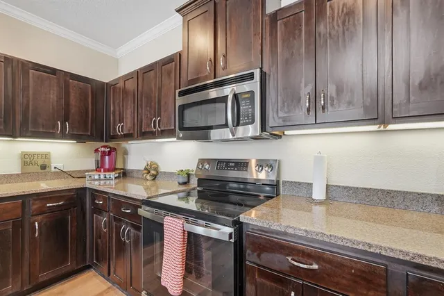 a kitchen with stainless steel appliances granite countertop a sink stove and microwave