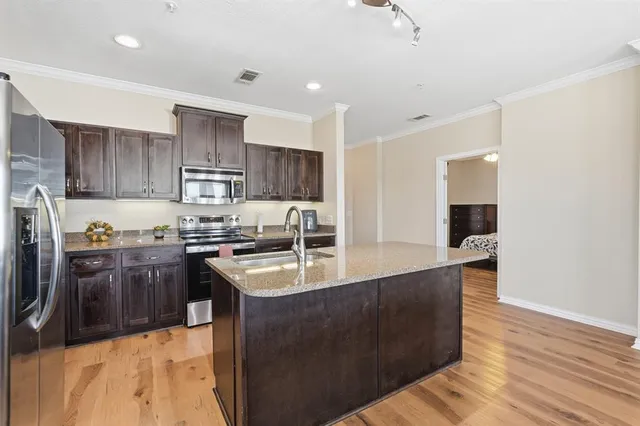 a kitchen with stainless steel appliances granite countertop a sink a stove and a refrigerator