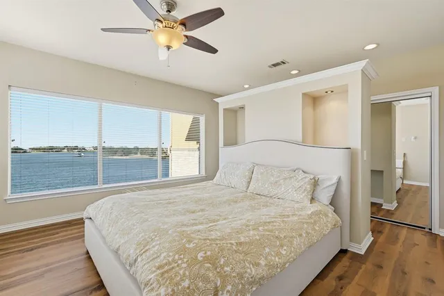 a bedroom with a large bed and a chandelier fan