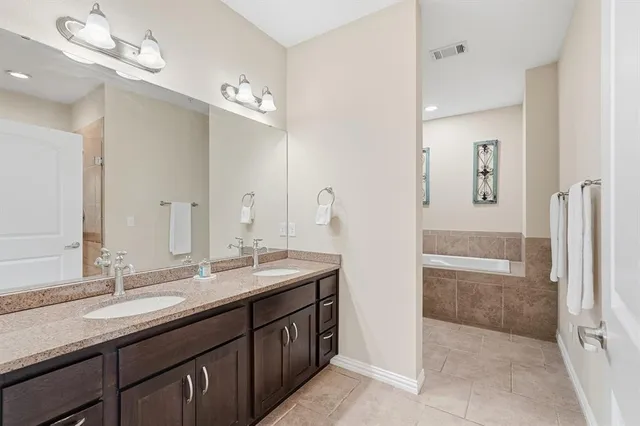 a bathroom with a granite countertop sink a large mirror and shower