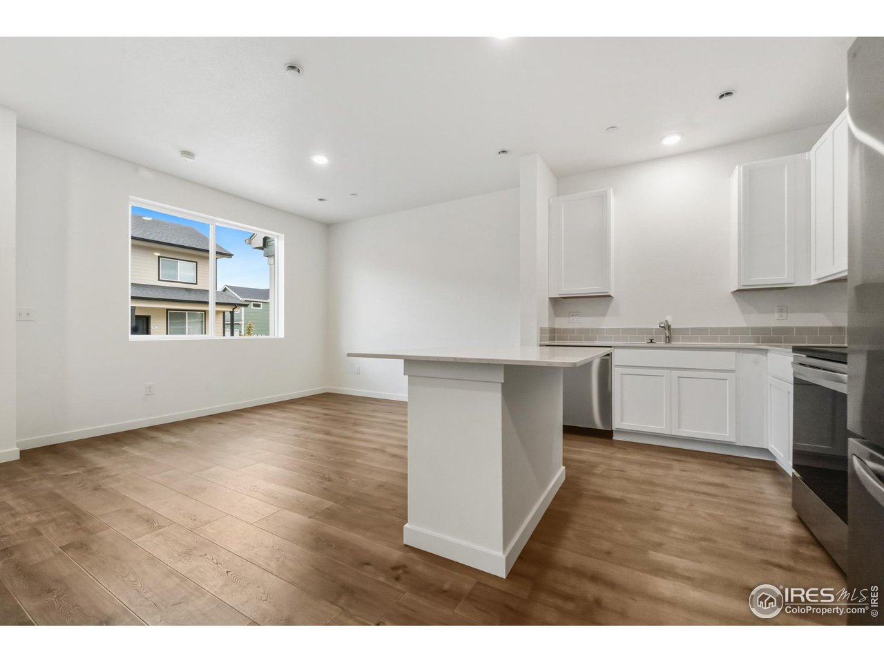 3912 Net Street Evans, CO 80620 - Photo 2 of 19 a kitchen with cabinets wooden floor and stainless steel appliances
