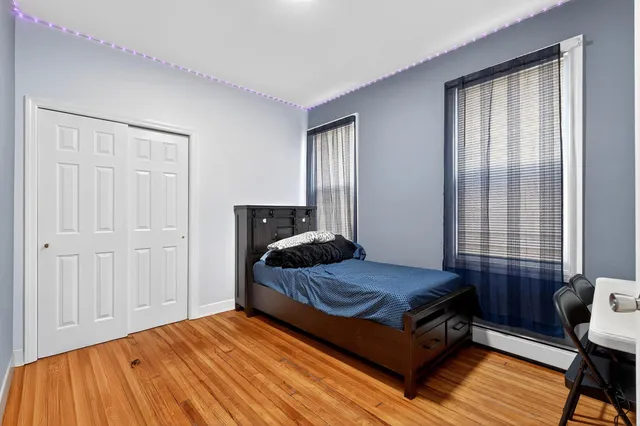 a bedroom with a bed and wooden floor