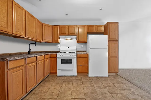 a kitchen with a white stove top oven and refrigerator