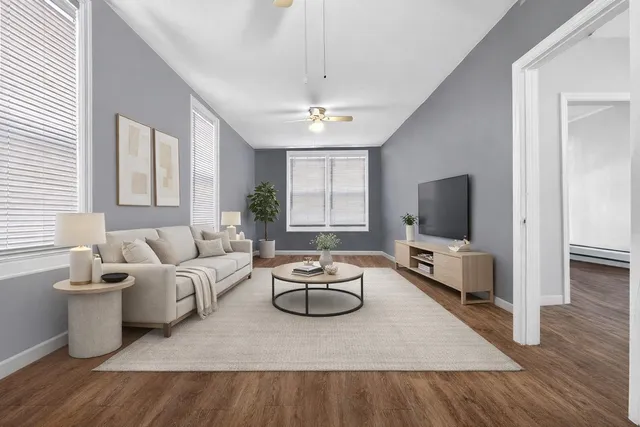 a living room with furniture a flat screen tv and a window