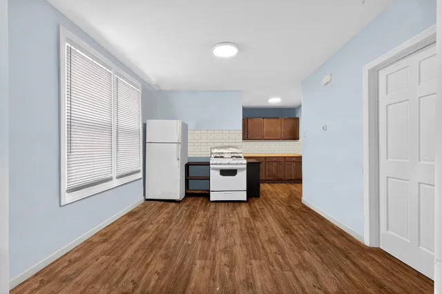 a view of a kitchen with wooden floor and electronic appliances