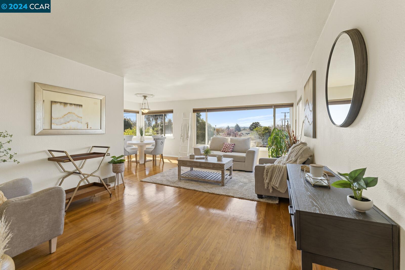 Undisclosed Address Richmond, CA 94805 - Photo 13 of 47 a living room with furniture a table a potted plant and a large window