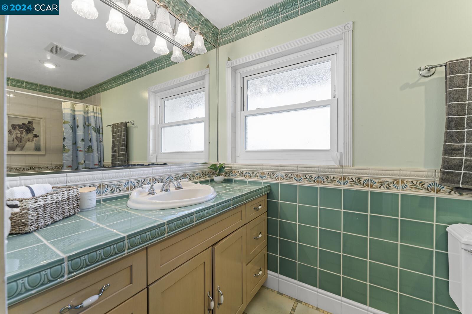 Undisclosed Address Richmond, CA 94805 - Photo 23 of 47 a bathroom with a granite countertop sink a mirror and a shower