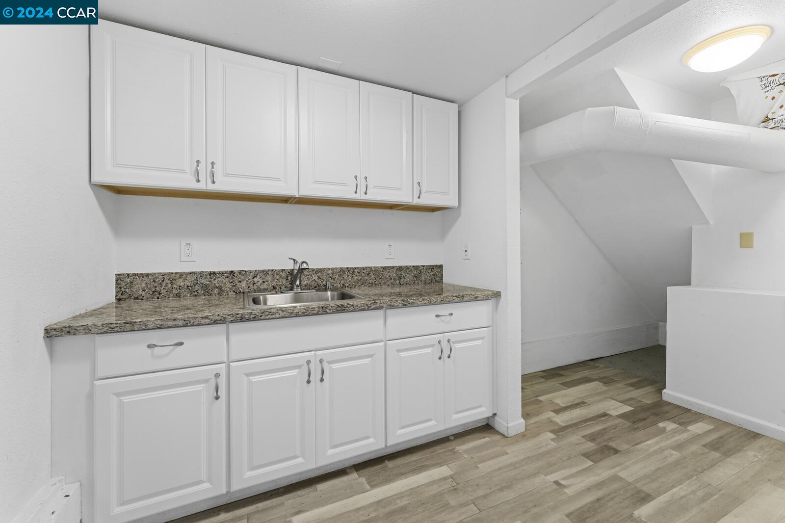 Undisclosed Address Richmond, CA 94805 - Photo 36 of 47 a kitchen with granite countertop white cabinets and a sink