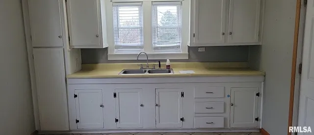 a kitchen with white cabinets and a sink