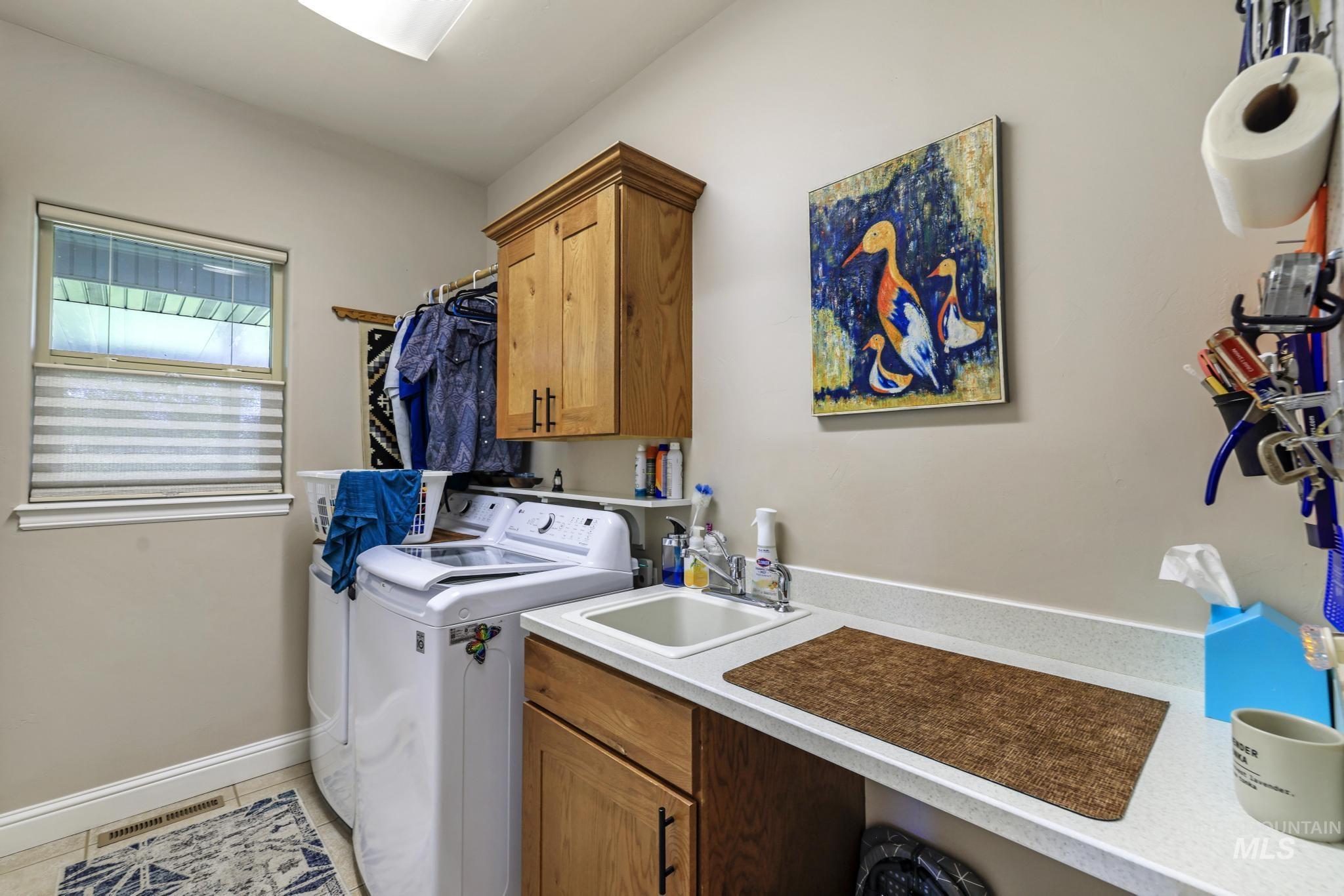 100 Olympic Road Jerome, ID 83338 - Photo 29 of 50 Dedicated laundry area featuring a utility sink, light wood cabinetry, and a work surface