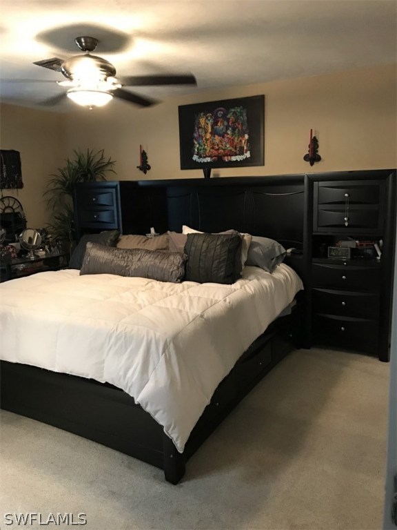 9104 Temple Road West Fort Myers, FL 33967 - Photo 9 of 12 a bedroom with a bed and a chandelier