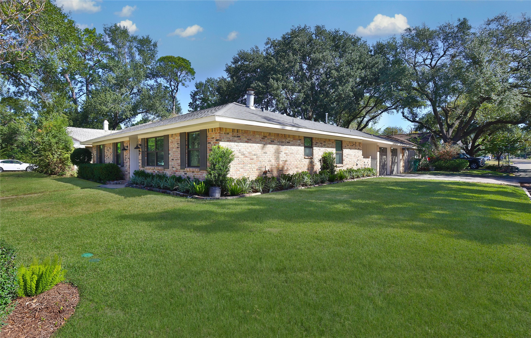 4402 Fallbrook Drive Houston, TX 77018 - Photo 3 of 29 Side view of the home highlighting the expansive yard, mature trees, and well-maintained landscaping