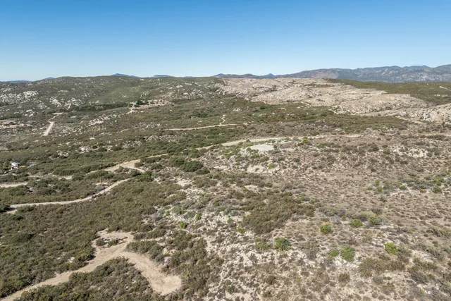 a view of a dry yard with mountains in the background