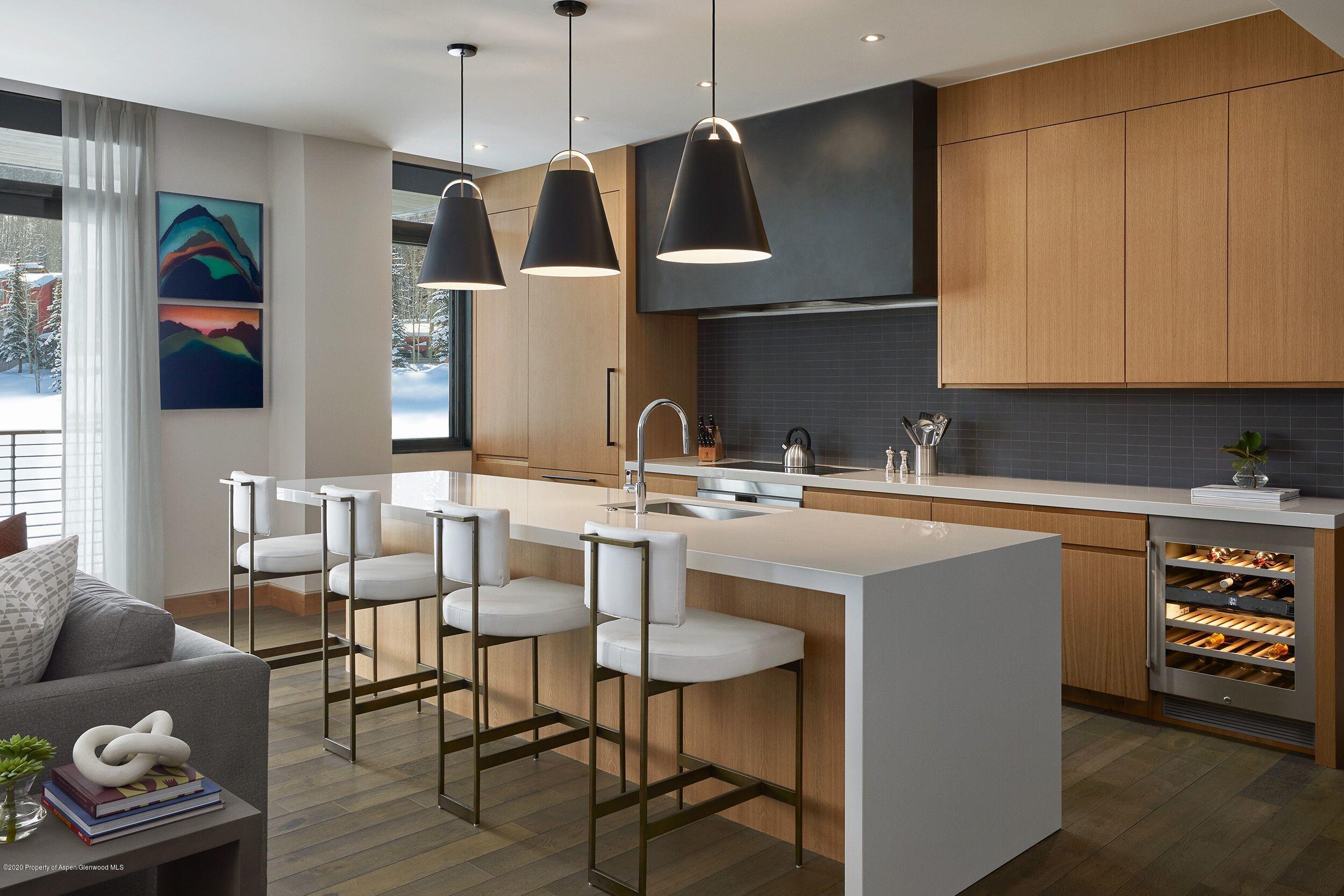 77 Wood Road, Unit 30651 Snowmass Village, CO 81615 - Photo 1 of 7 a kitchen with stainless steel appliances granite countertop a sink a microwave a refrigerator and chairs