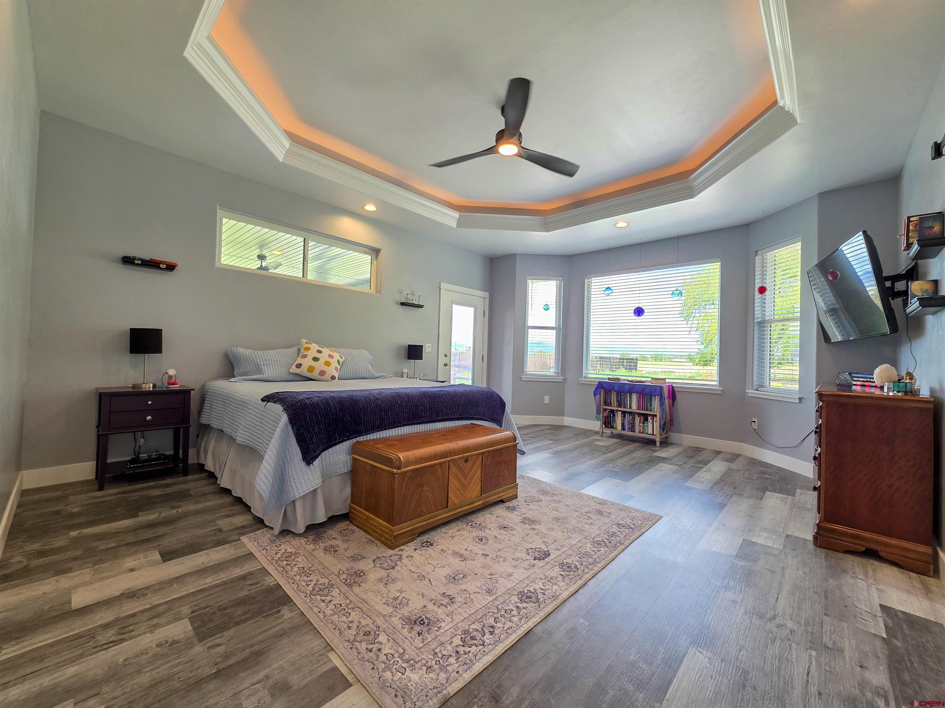 1771 Trappers Court Delta, CO 81416 - Photo 11 of 44 a spacious bedroom with a bed a chandelier and a dresser