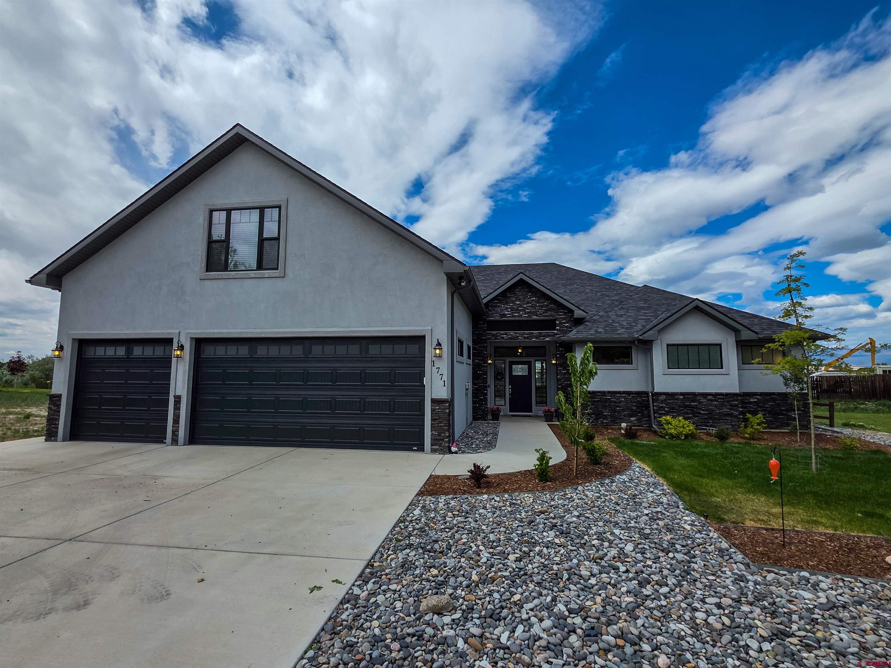 1771 Trappers Court Delta, CO 81416 - Photo 38 of 44 a front view of a house with a yard and garage