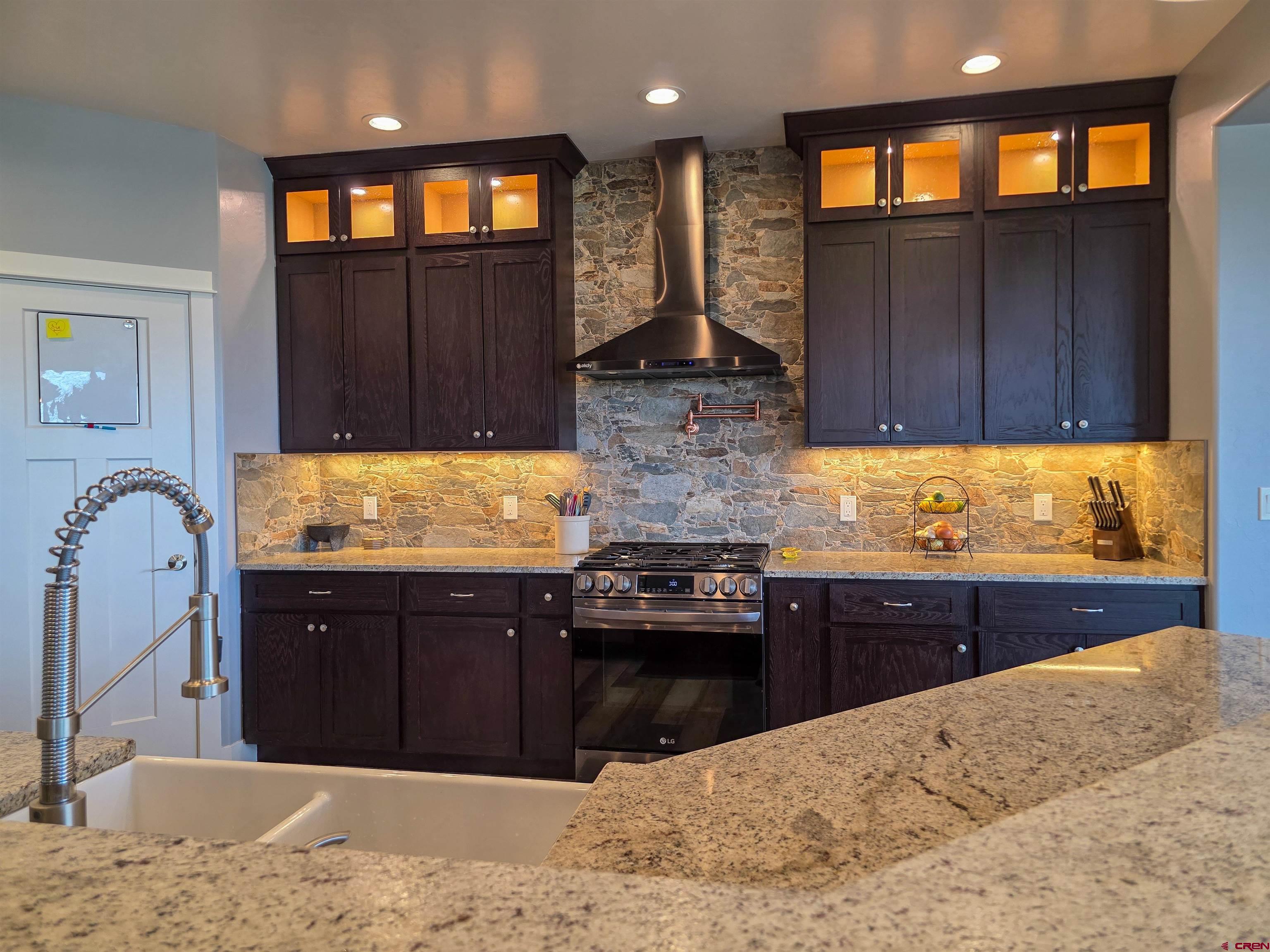 1771 Trappers Court Delta, CO 81416 - Photo 5 of 44 a kitchen with stainless steel appliances granite countertop wooden cabinets a stove top oven and granite counter tops