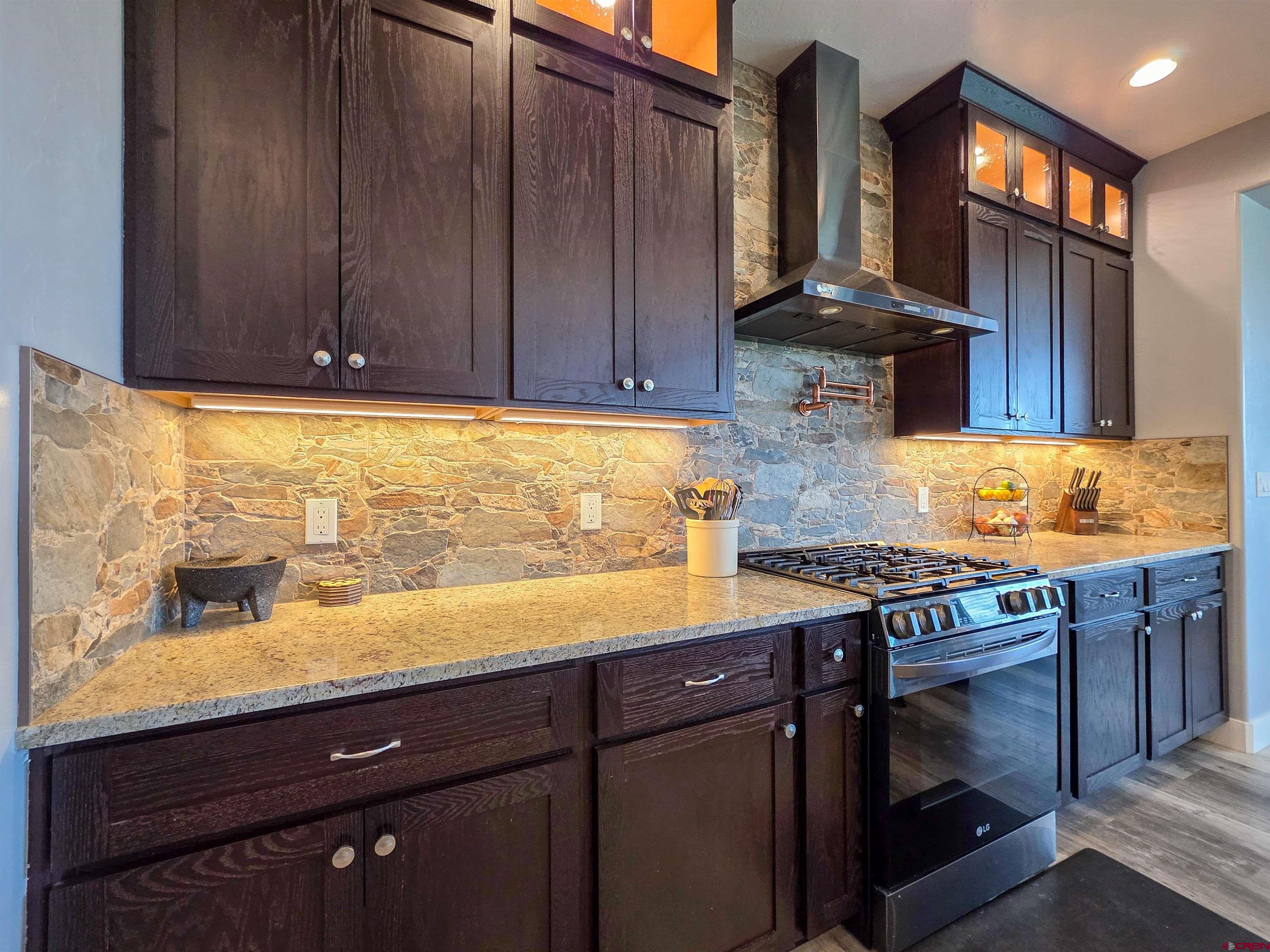 1771 Trappers Court Delta, CO 81416 - Photo 7 of 44 a kitchen with granite countertop wooden cabinets and a stove top oven