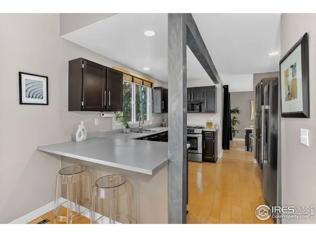 a kitchen view with stainless steel appliances kitchen island granite countertop a sink and cabinets