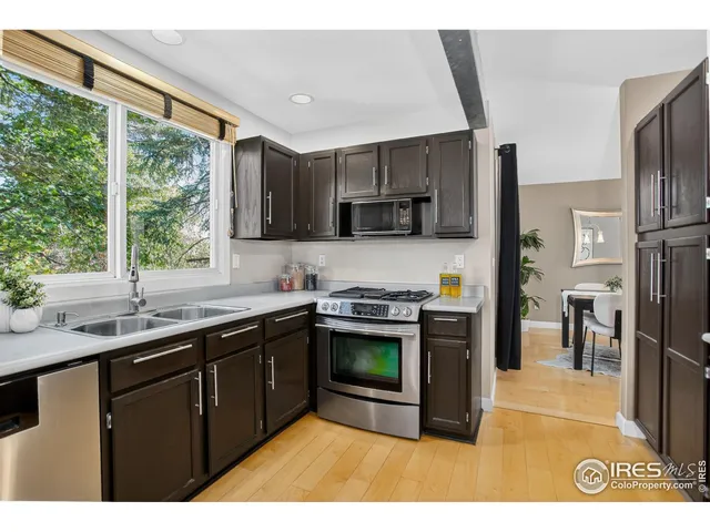 a kitchen with stainless steel appliances granite countertop a sink a stove a refrigerator a sink a counter top space and cabinets