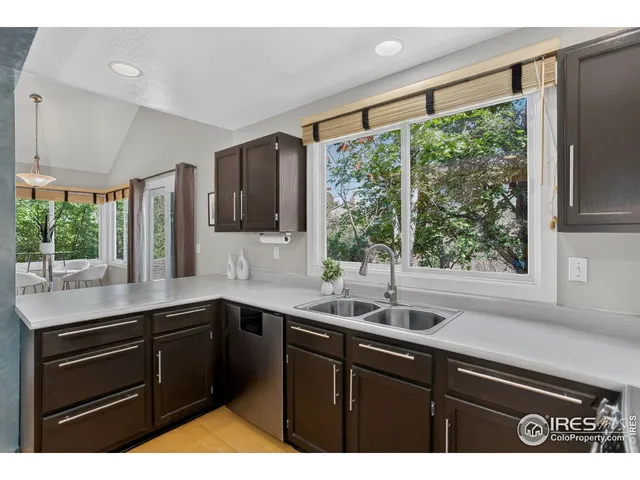 a kitchen with a sink large window and cabinets