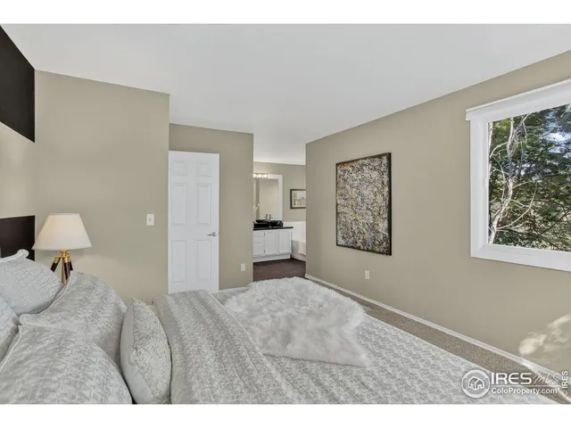 a bedroom with a bed and a painting on the wall