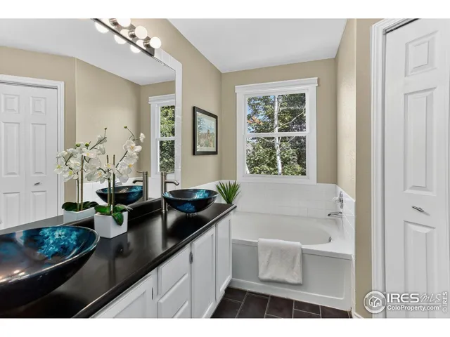 a bathroom with a granite countertop sink a large mirror and bathtub