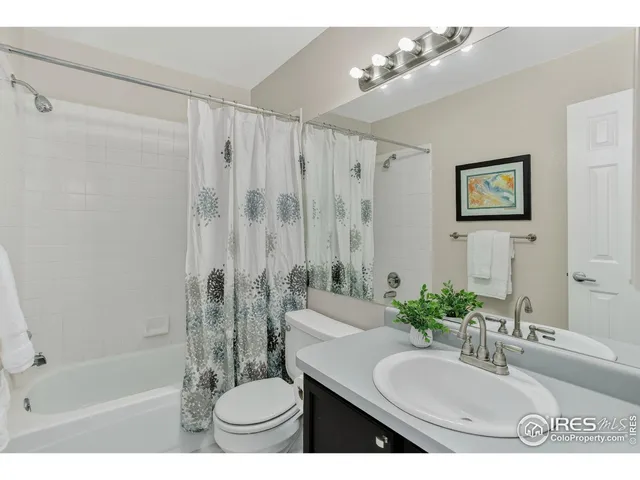 a bathroom with a granite countertop sink a toilet a mirror and shower
