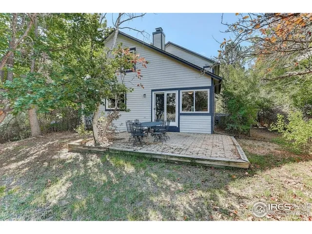 a view of a house with backyard and trees