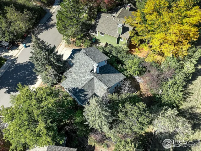 an aerial view of residential house with outdoor space and trees all around