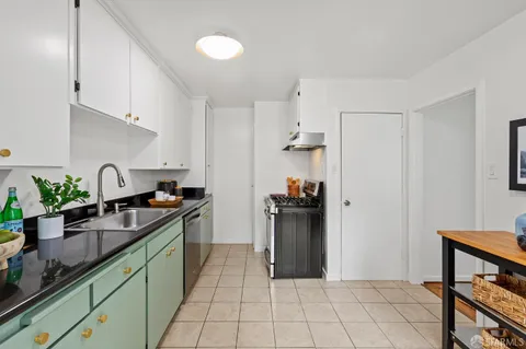 a kitchen with granite countertop a sink stove and cabinets