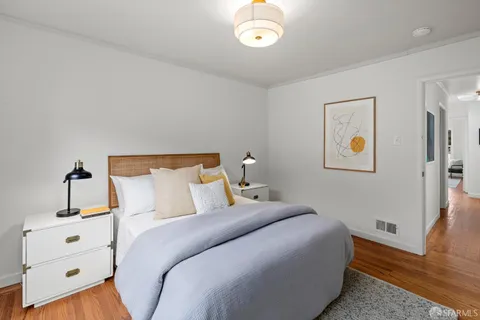 a bedroom with a bed and wooden floor