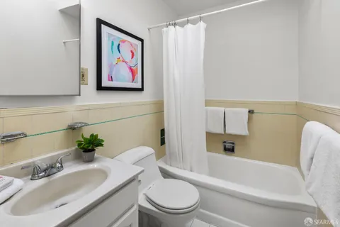 a bath room with a toilet a sink and a bath tub