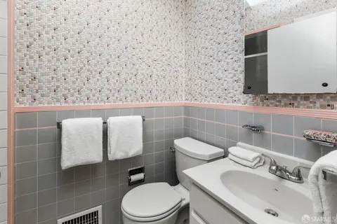 a bathroom with a sink mirror and toilet
